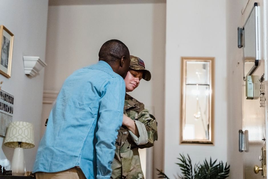 A spouse helping an older veteran review aid and attendance pension paperwork at home